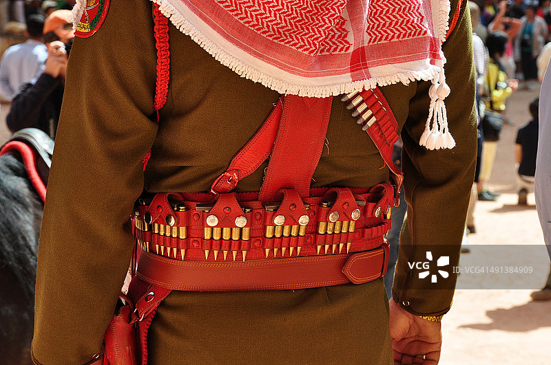 约旦佩特拉的传统服饰和头戴库非耶头巾的警察图片素材