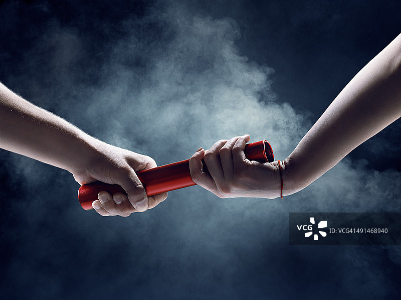 赛跑中接力棒交接的特写图片素材