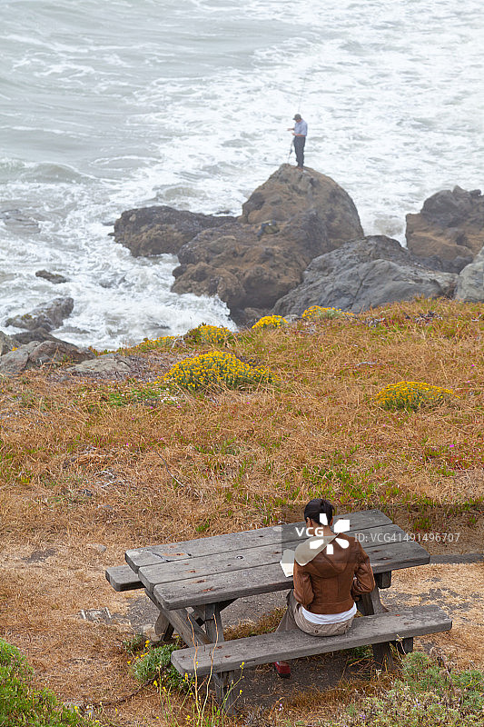女人在雾蒙蒙的早晨在海边读书图片素材
