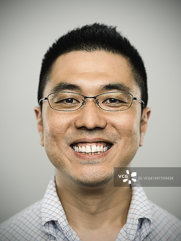 看着镜头的快乐年轻日本男人的肖像图片素材