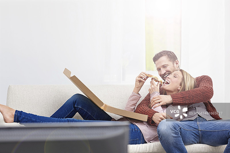 情侣在家中享用披萨图片素材