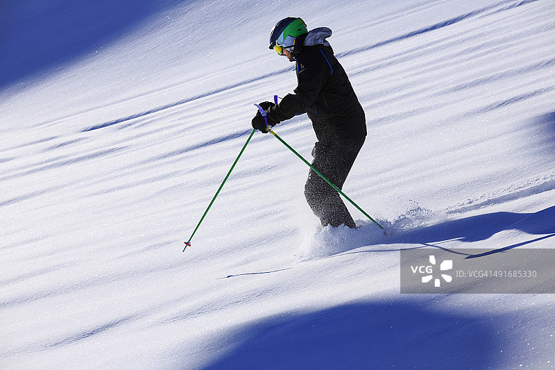 男人们在阳光明媚的滑雪胜地进行野雪粉雪滑雪图片素材