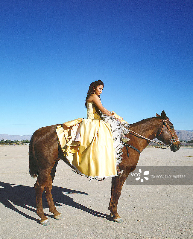 穿着十五岁成人礼服，骑在马上的女孩图片素材