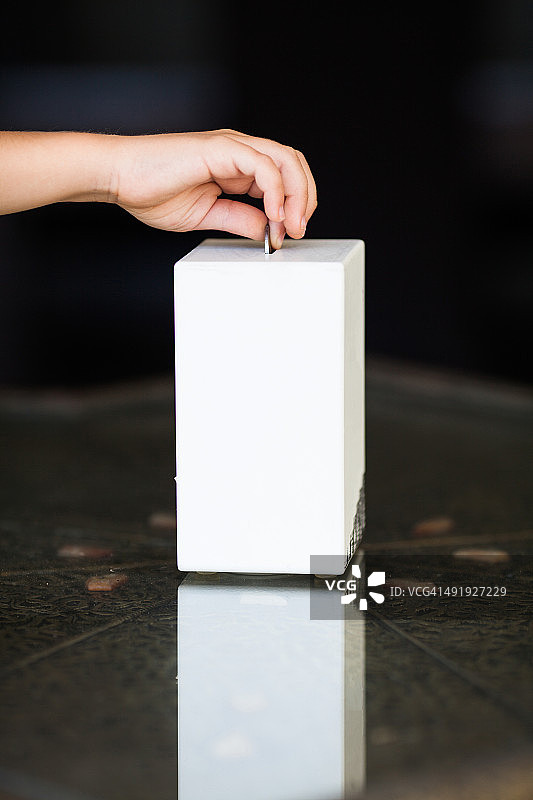 手将硬币放入储蓄罐图片素材