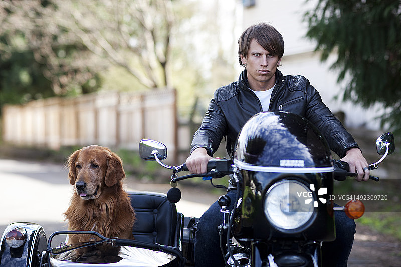 骑摩托车的英俊男人和他的狗图片素材