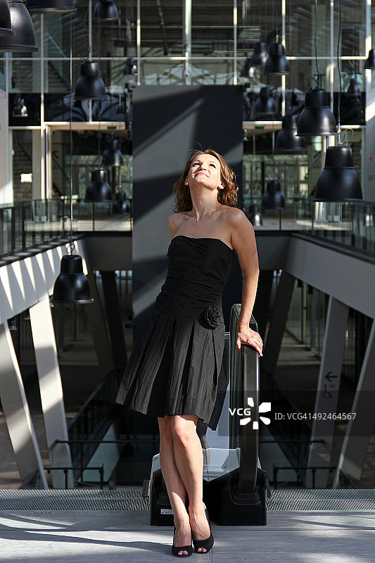 光线照耀着穿着黑色连衣裙的女人图片素材