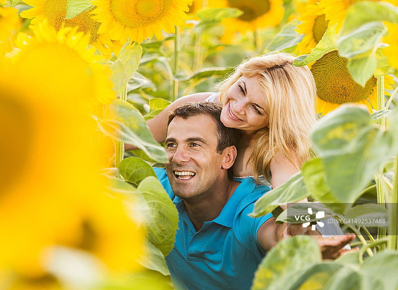 向日葵田中快乐情侣骑在背上图片素材