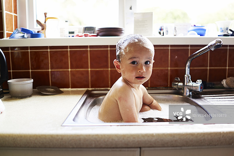 男孩在水槽里洗澡图片素材