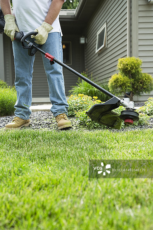 男子在后院割草图片素材