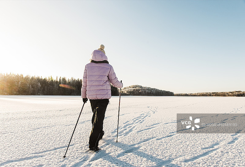 在雪地里北欧式健走的女人图片素材