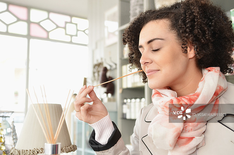 年轻女子在精品店闻香图片素材