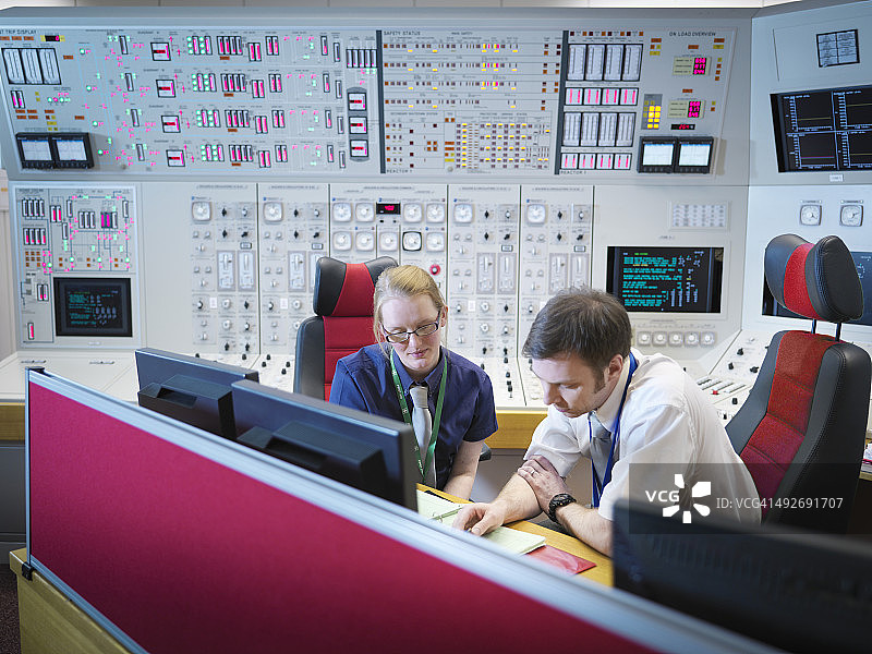 核电站控制室模拟器中的女操作员与实习生图片素材