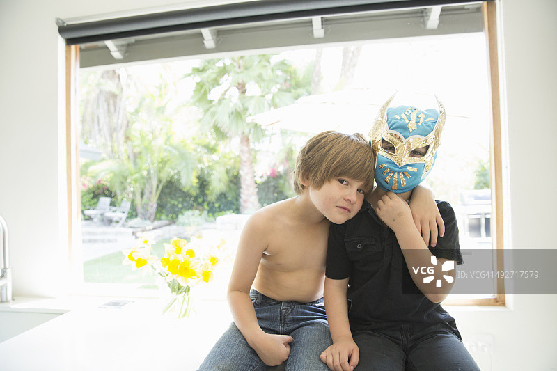 两个兄弟的肖像，一个赤裸上身，一个戴着面具图片素材