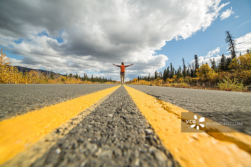 站在路上伸开双臂的远处女人图片素材