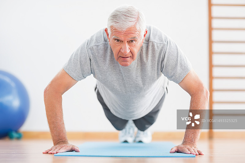积极锻炼的年长男人做俯卧撑图片素材