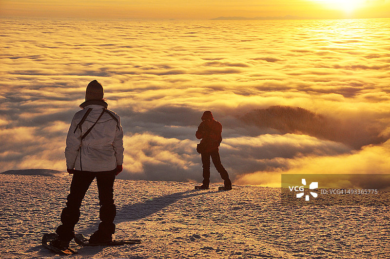情侣在山顶穿着雪鞋图片素材