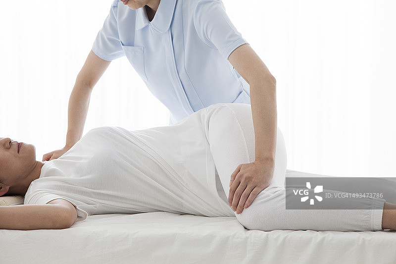 年轻女子接受理疗师治疗图片素材