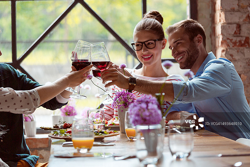 朋友们享受晚餐，举杯红酒图片素材