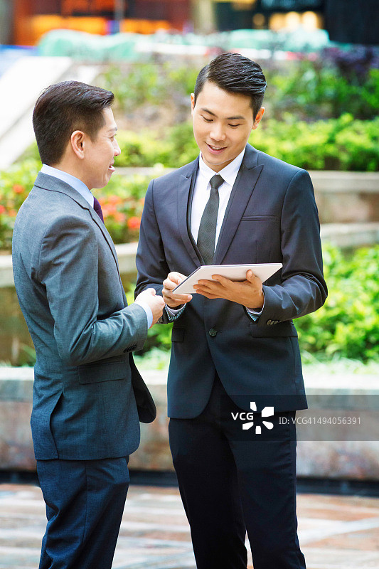 户外：使用平板电脑进行商务洽谈图片素材