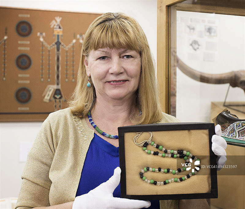 博物馆里拿着古代珠子的白人馆长图片素材