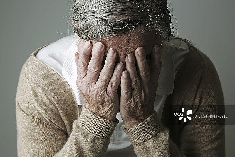 年长的女人用手捂住脸图片素材