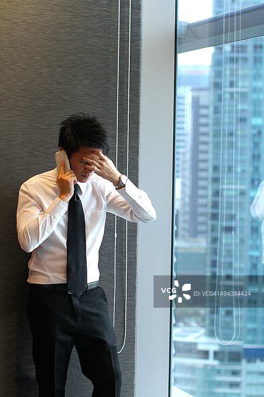 听到坏消息的年轻亚洲商人图片素材