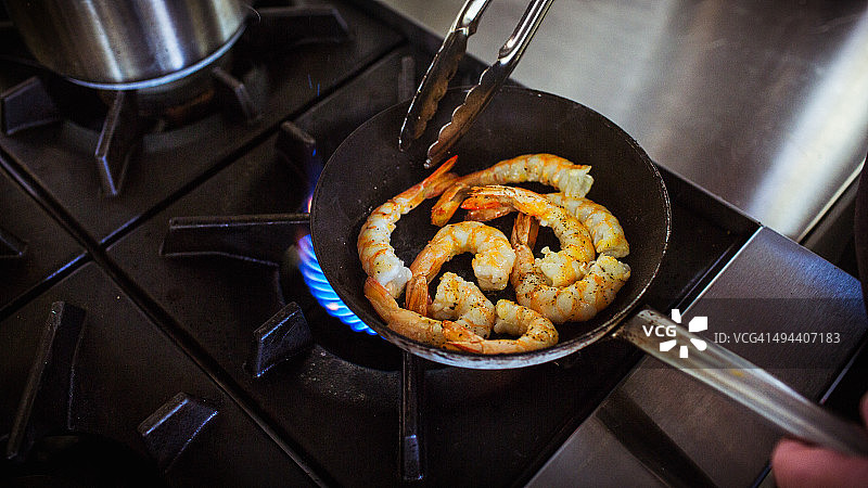 厨师在煎锅中烹饪虾图片素材