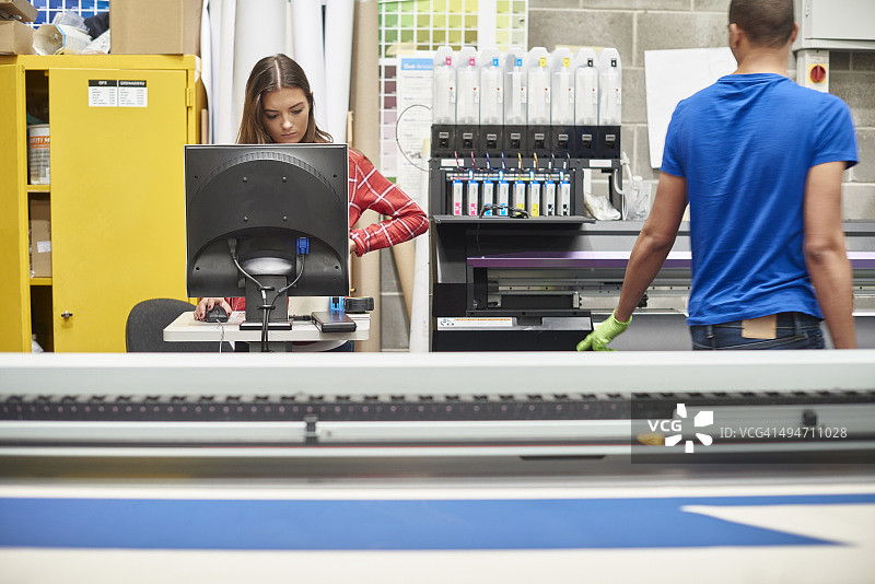 在数码印刷公司工作的年轻女人图片素材