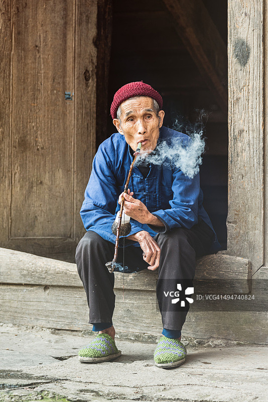 中国94岁老人在家门口抽烟斗图片素材