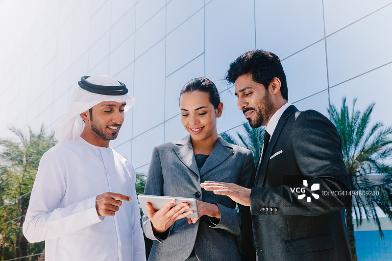 中东商人和女商人使用数字平板电脑在户外工作图片素材