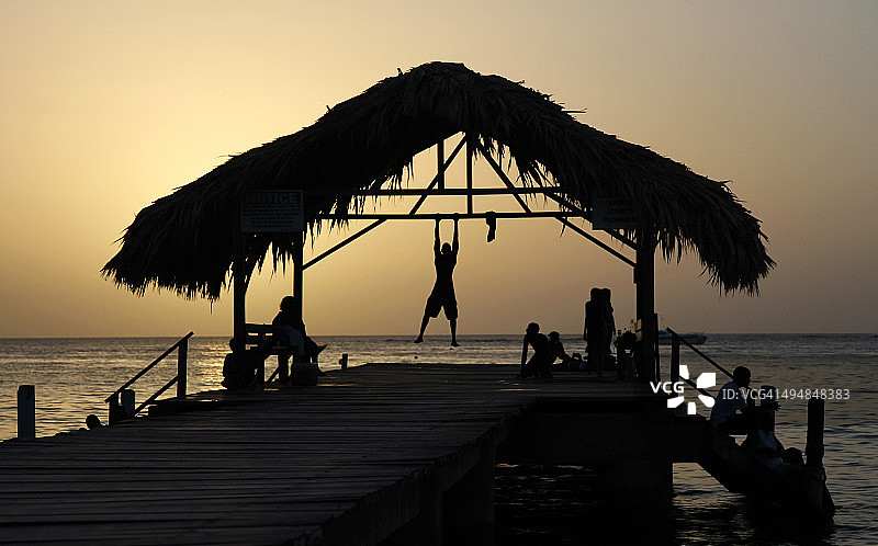 茅草屋顶小岛加勒比日落金色剪影图片素材