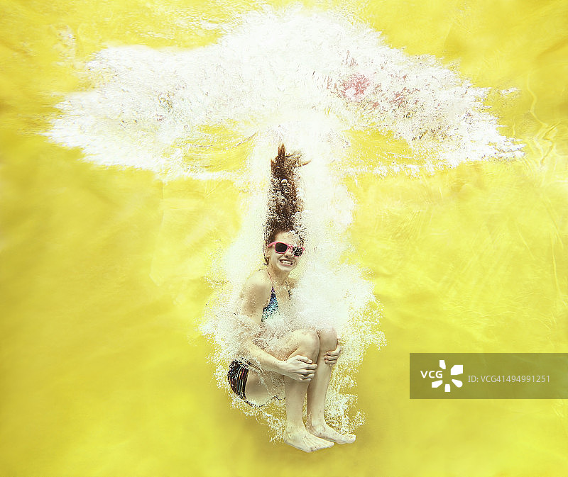 黄色背景上的女孩跳水图片素材