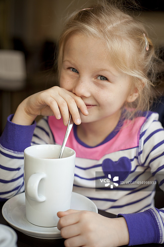 小女孩在咖啡馆摆姿势图片素材