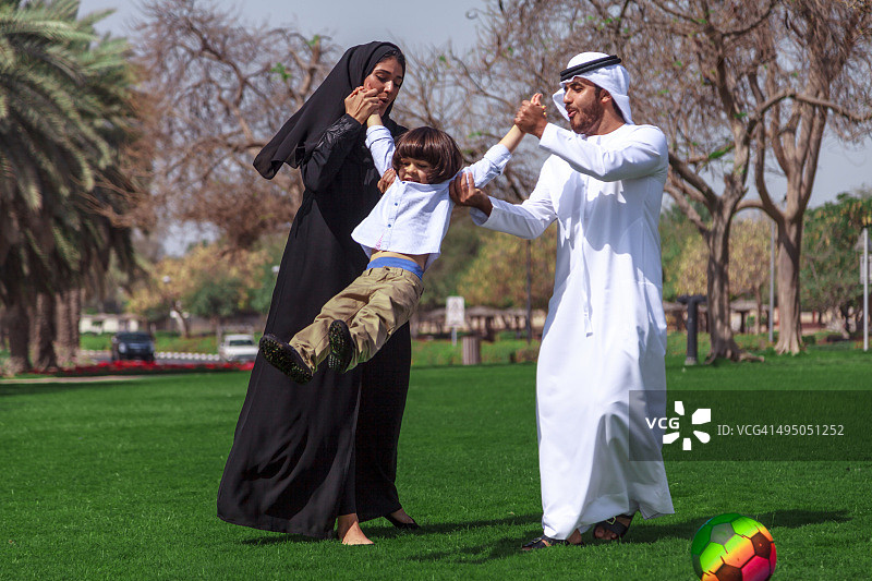 在阳光明媚的日子里，传统的年轻阿拉伯家庭在户外玩耍图片素材