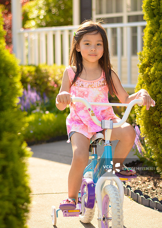 小女孩在前院骑自行车图片素材