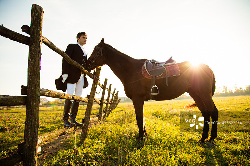 男人站在草地上与马为伴图片素材
