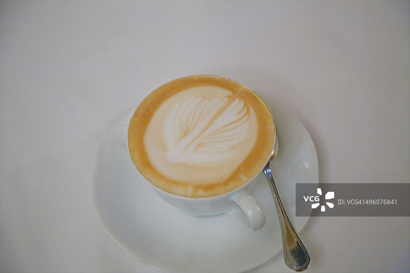 卡布奇诺咖啡杯上的树叶图案图片素材