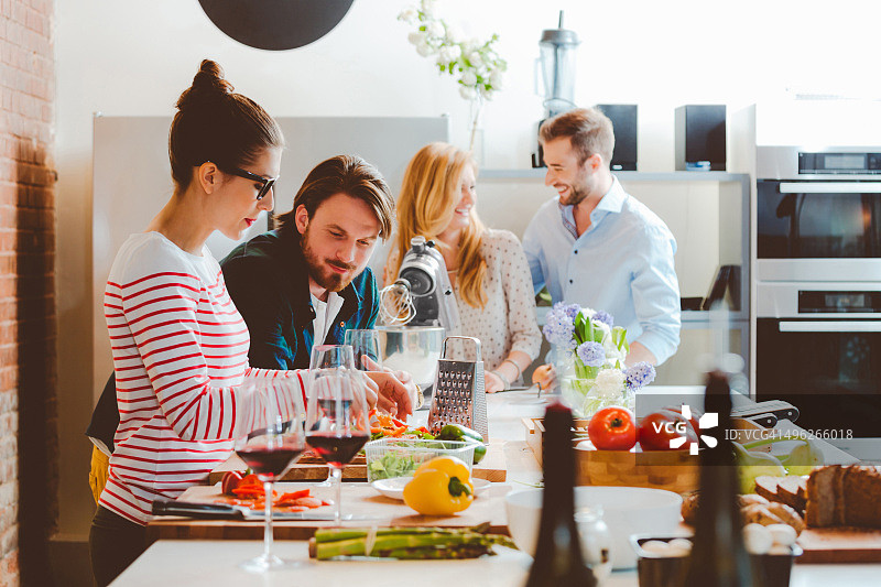 朋友们在现代厨房一起烹饪图片素材