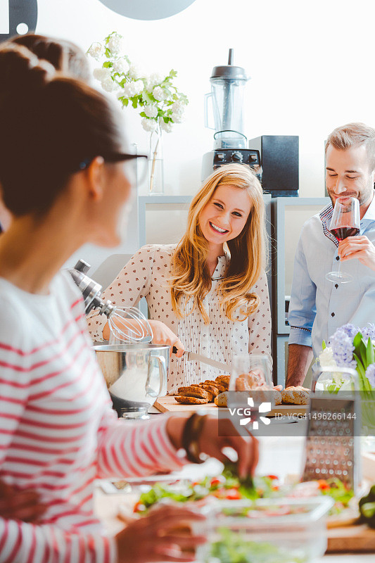 朋友们在现代厨房一起烹饪图片素材