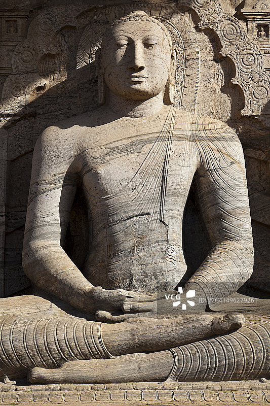 依附岩石的坐佛雕像图片素材