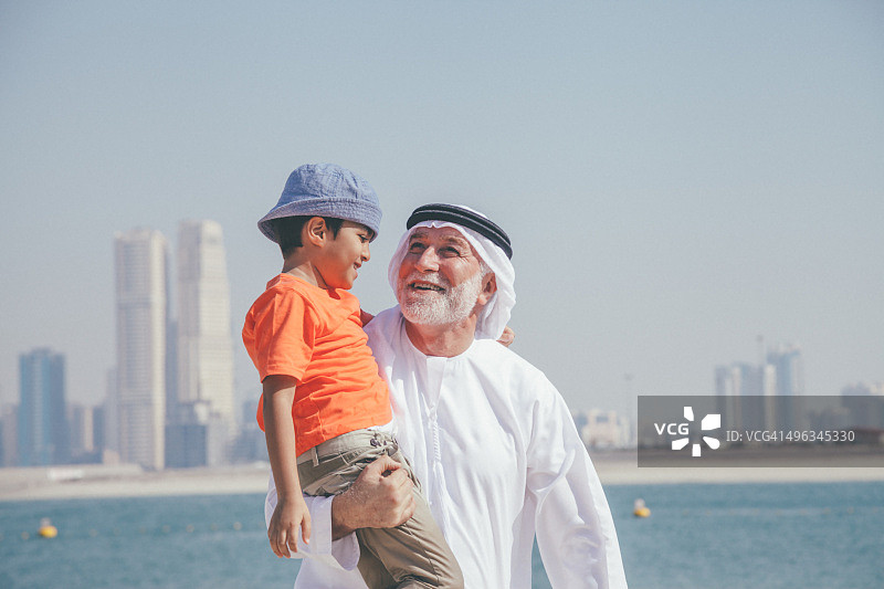 阿拉伯祖孙在沙滩玩耍图片素材