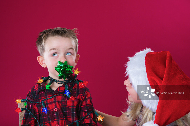 裹在圣诞彩灯里的小男孩图片素材