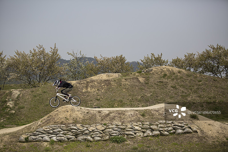 年轻女人在赛道上骑BMX自行车图片素材