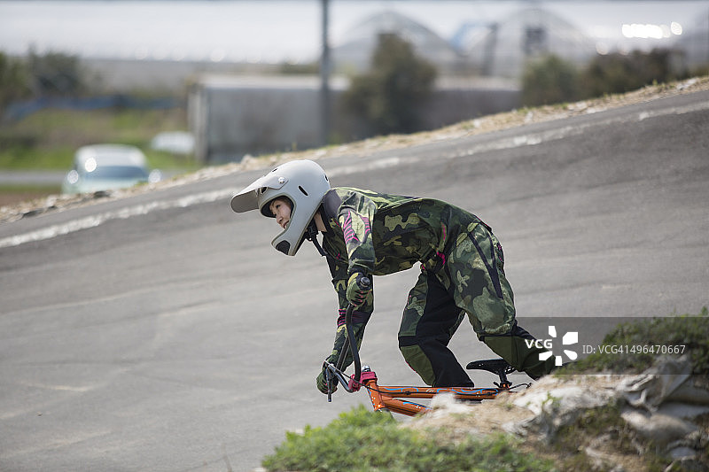年轻女人在赛道上骑BMX自行车图片素材
