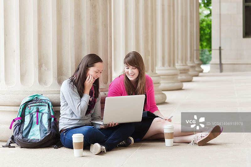 快乐的学生在大学校园用WIFI笔记本电脑学习图片素材