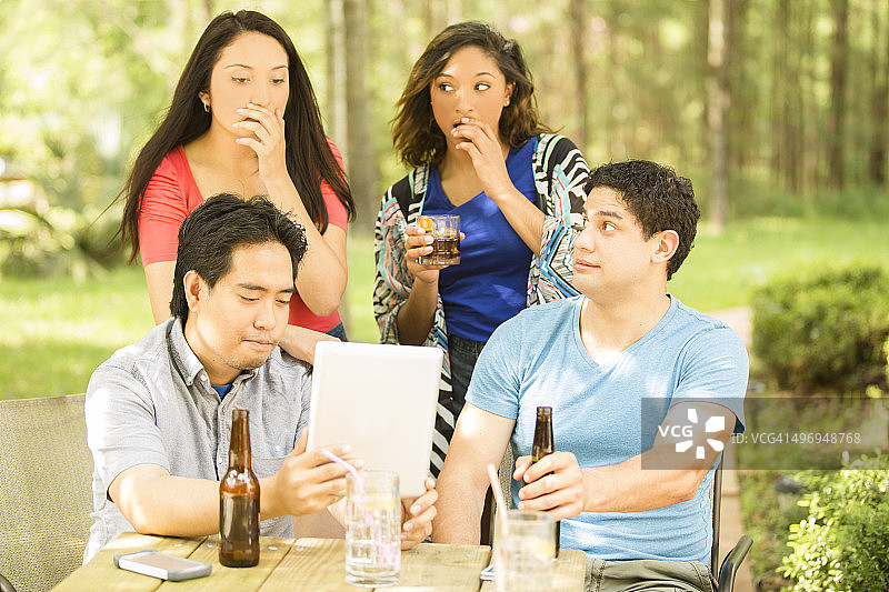 年轻的朋友在户外用平板电脑观看视频图片素材