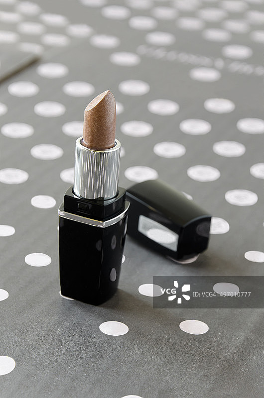 波点背景上的棕色唇膏图片素材