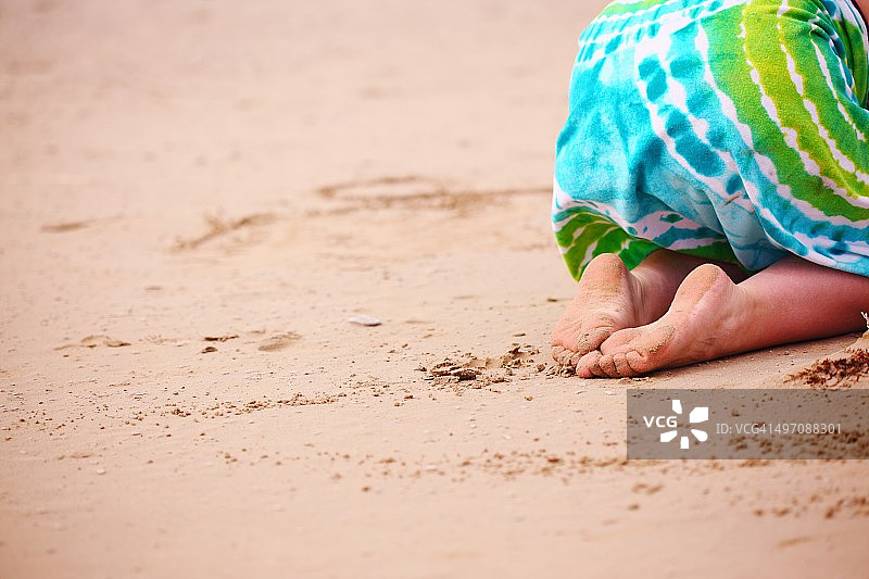 赤脚跪在沙滩上的女孩图片素材