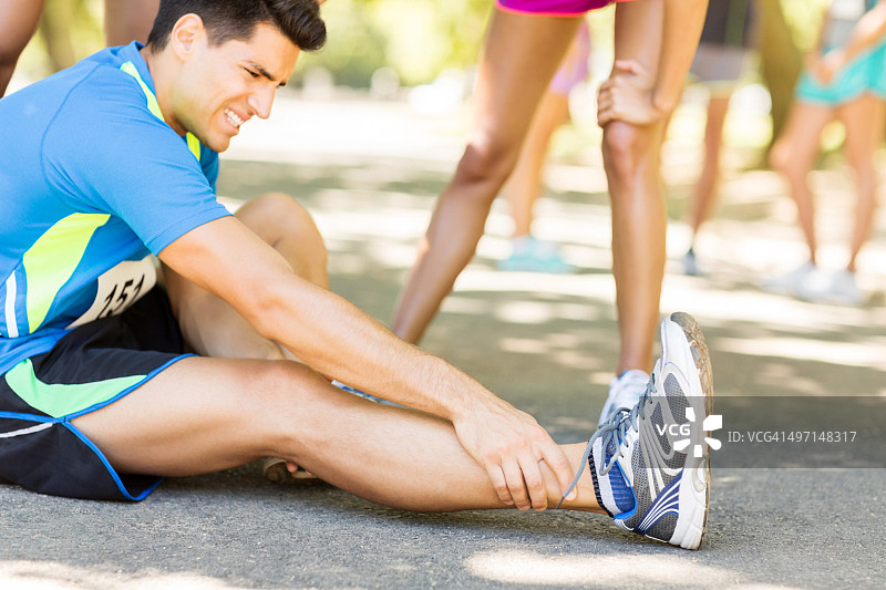 马拉松期间在街上脚踝疼痛的男人图片素材