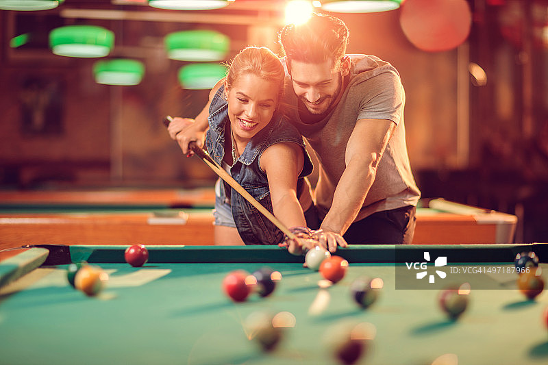 快乐的男人教他的女朋友如何打斯诺克图片素材